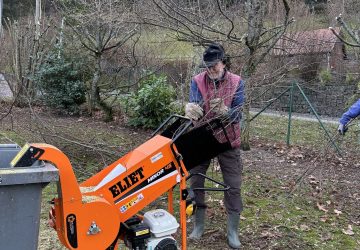 homme utilisant une broyeuse après la taille des arbres