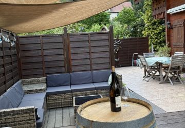 vue avec en arrière un salon de jardin sur la terrasse