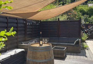 tonneau en bois posé sur la terrasse avec une bouteille de vin d'alsace